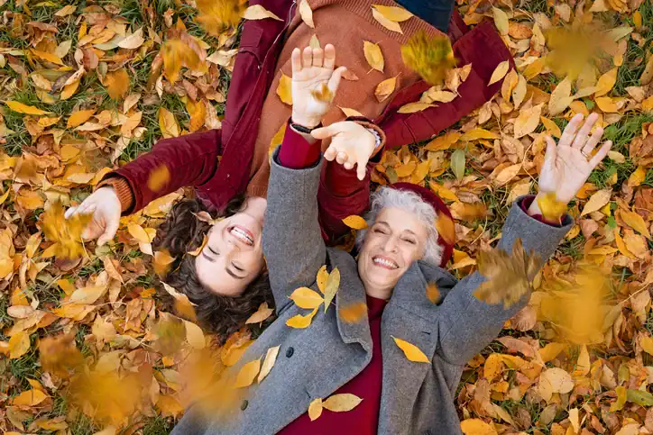 two women in fall leaves